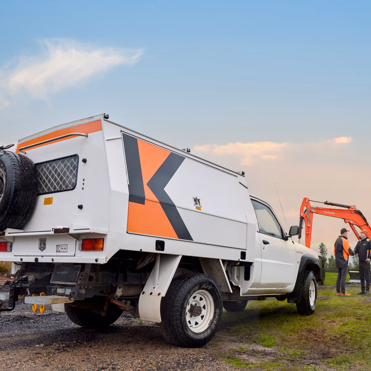 Fully equipped field service vehicle parked beside a Kubota excavator on a job site.