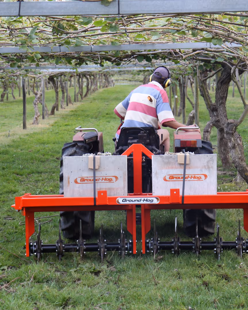 Operator running a Groundhog implement between rows in a kiwifruit orchard