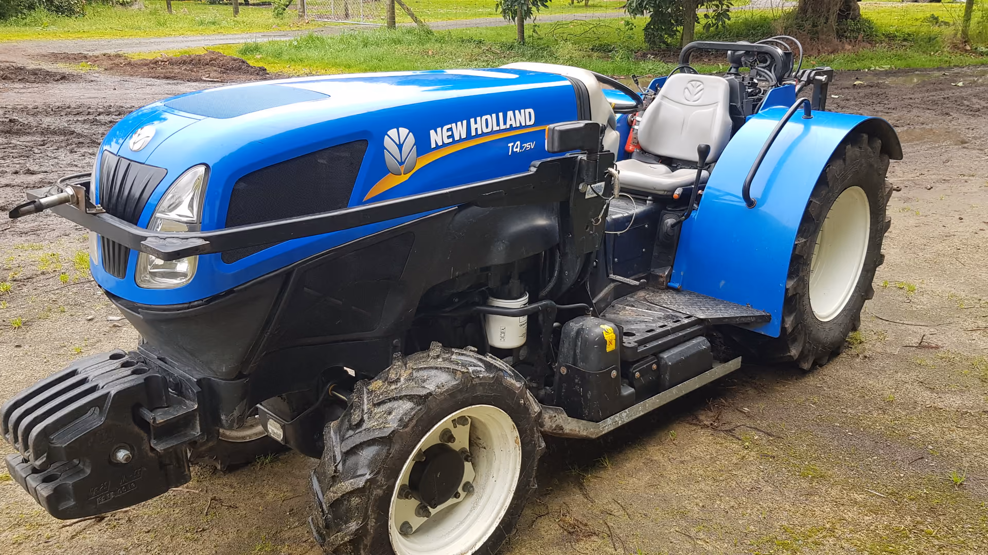 New Holland T4 orchard tractor beside a shelter hedge