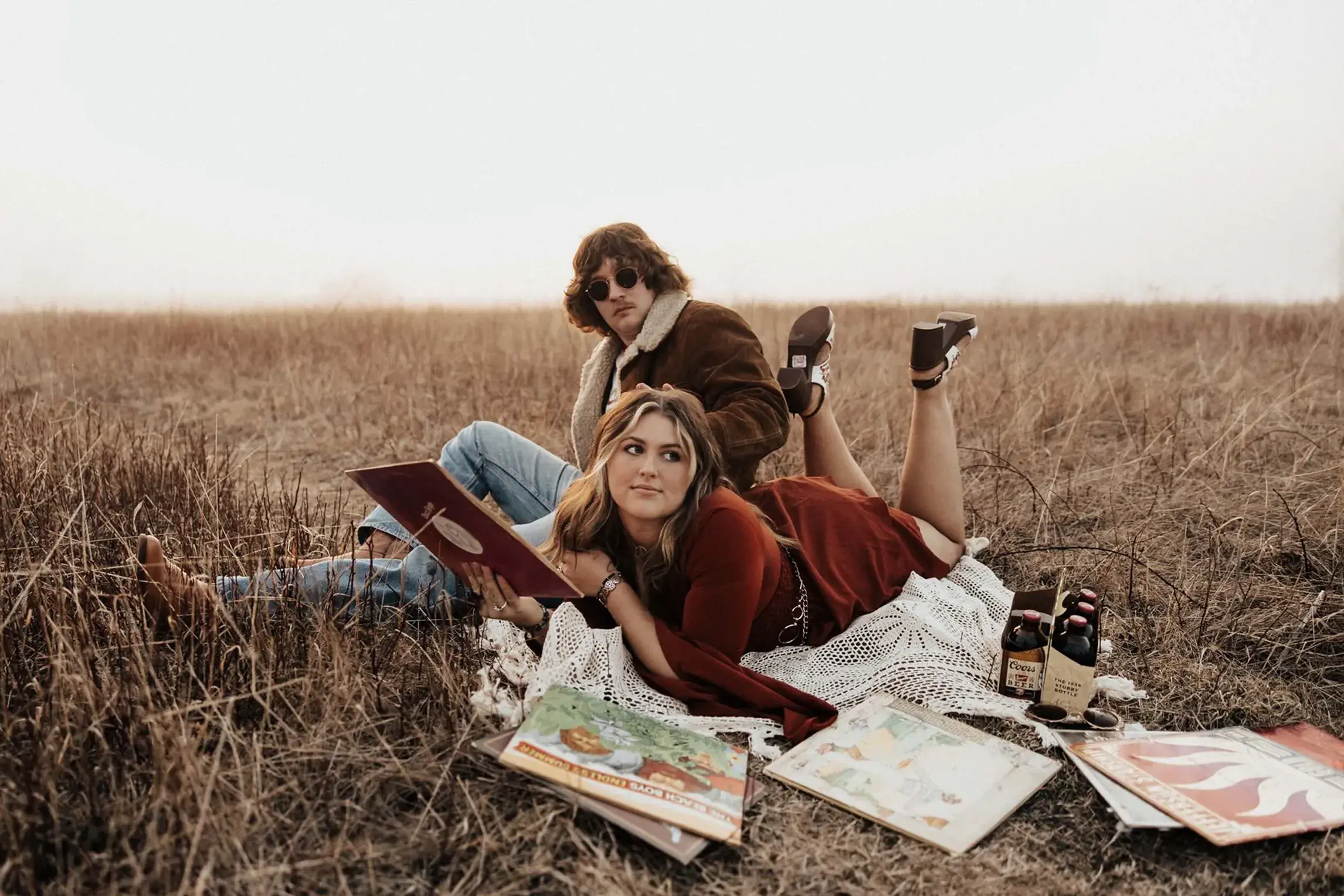 Couple enjoying a retro-inspired picnic in an open field near Shenandoah National Park, with vintage records, a record player, and a laid-back hippy aesthetic creating a nostalgic atmosphere.