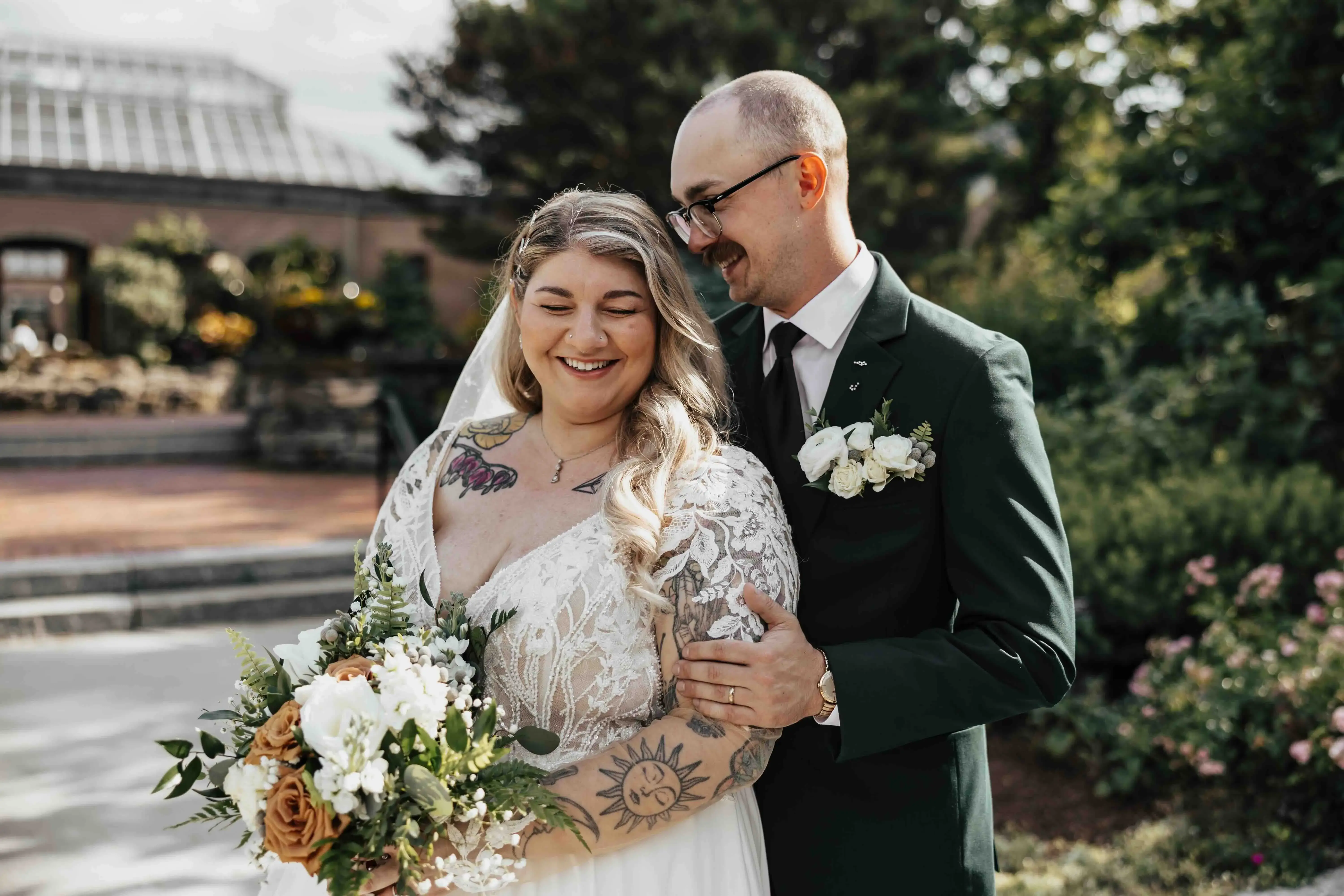 Bride and groom sharing a joyful moment in the gardens at Tower Hill Botanic Garden near Worcester, Massachusetts, during their New England wedding.