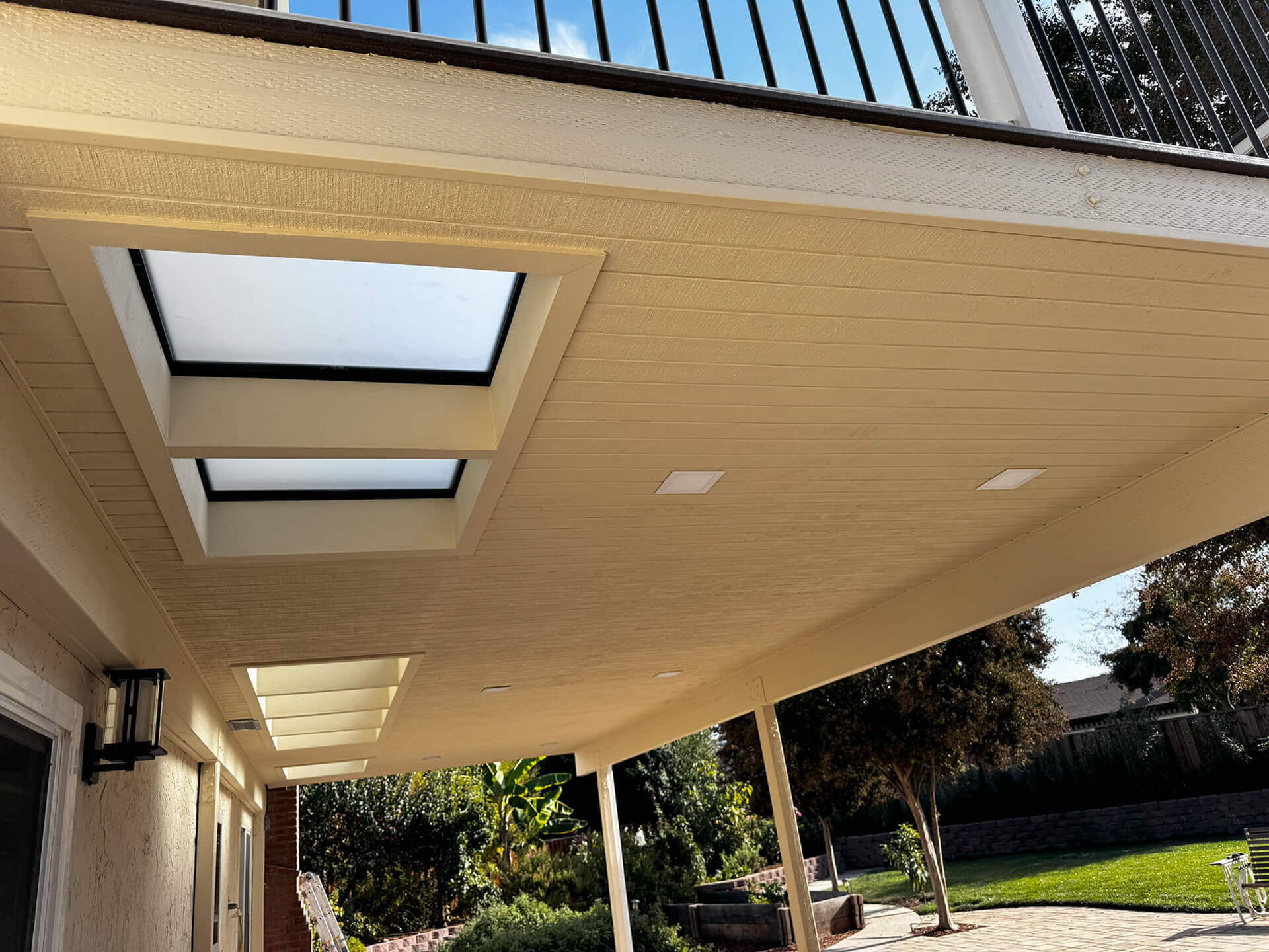 Custom covered patio with skylights and a contemporary wood ceiling in San Jose
