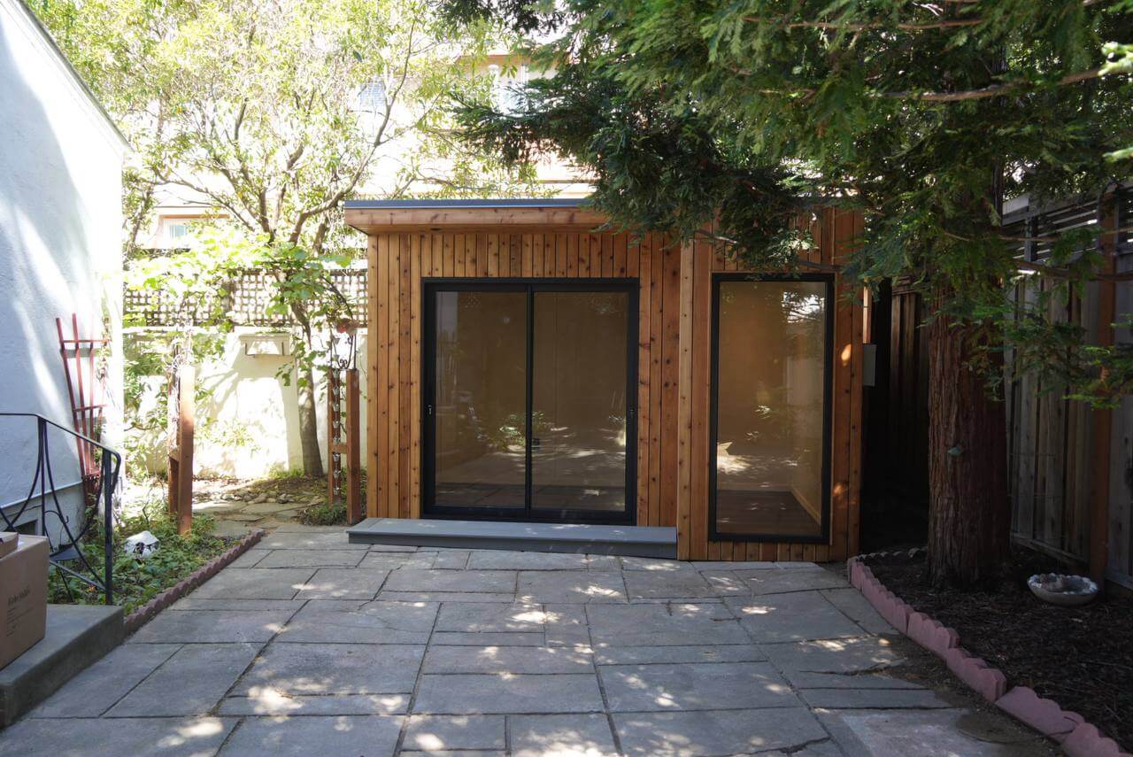 Stokton backyard studio shed with natural wood siding, glass doors, and a modern design in the San Francisco Bay Area, California