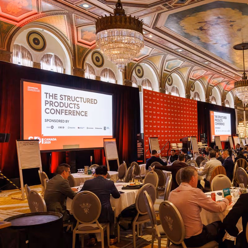 Business professionals seated at round tables in ornate hall during SPI Canada 2025, The Structured Products Conference.