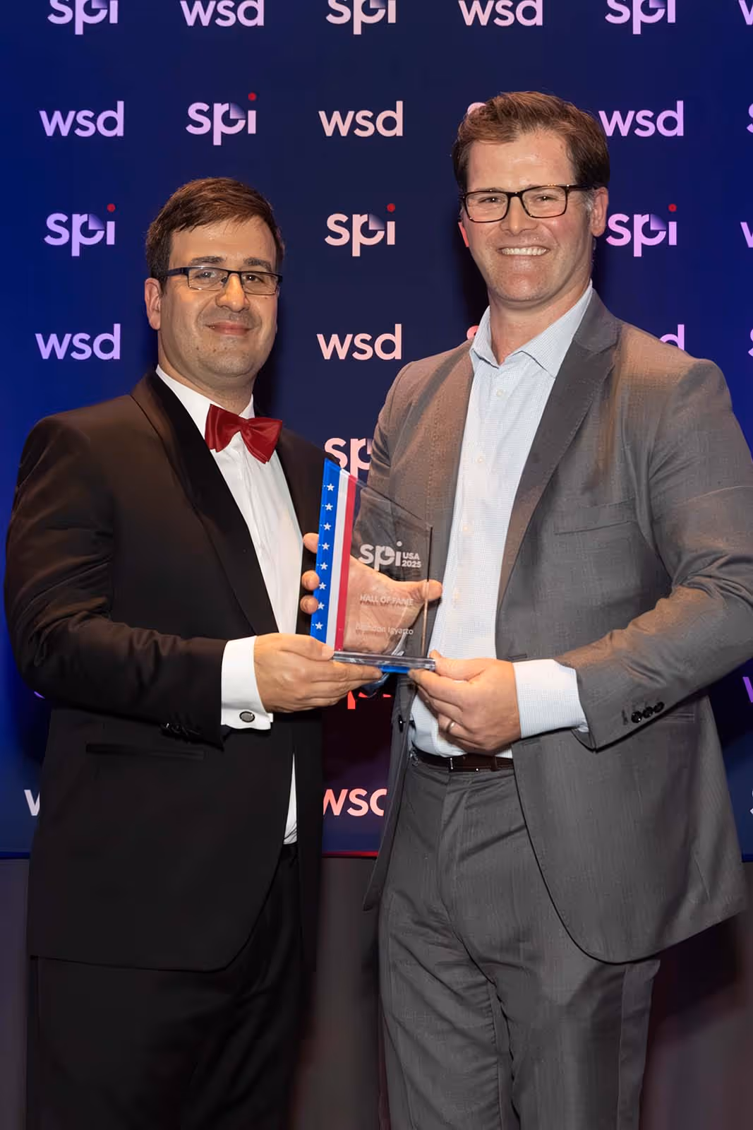 Tiago Fernandes presenting the Hall of Fame Award to Brandon Igyarto at SPI USA 2025, the Structured Products Conference.