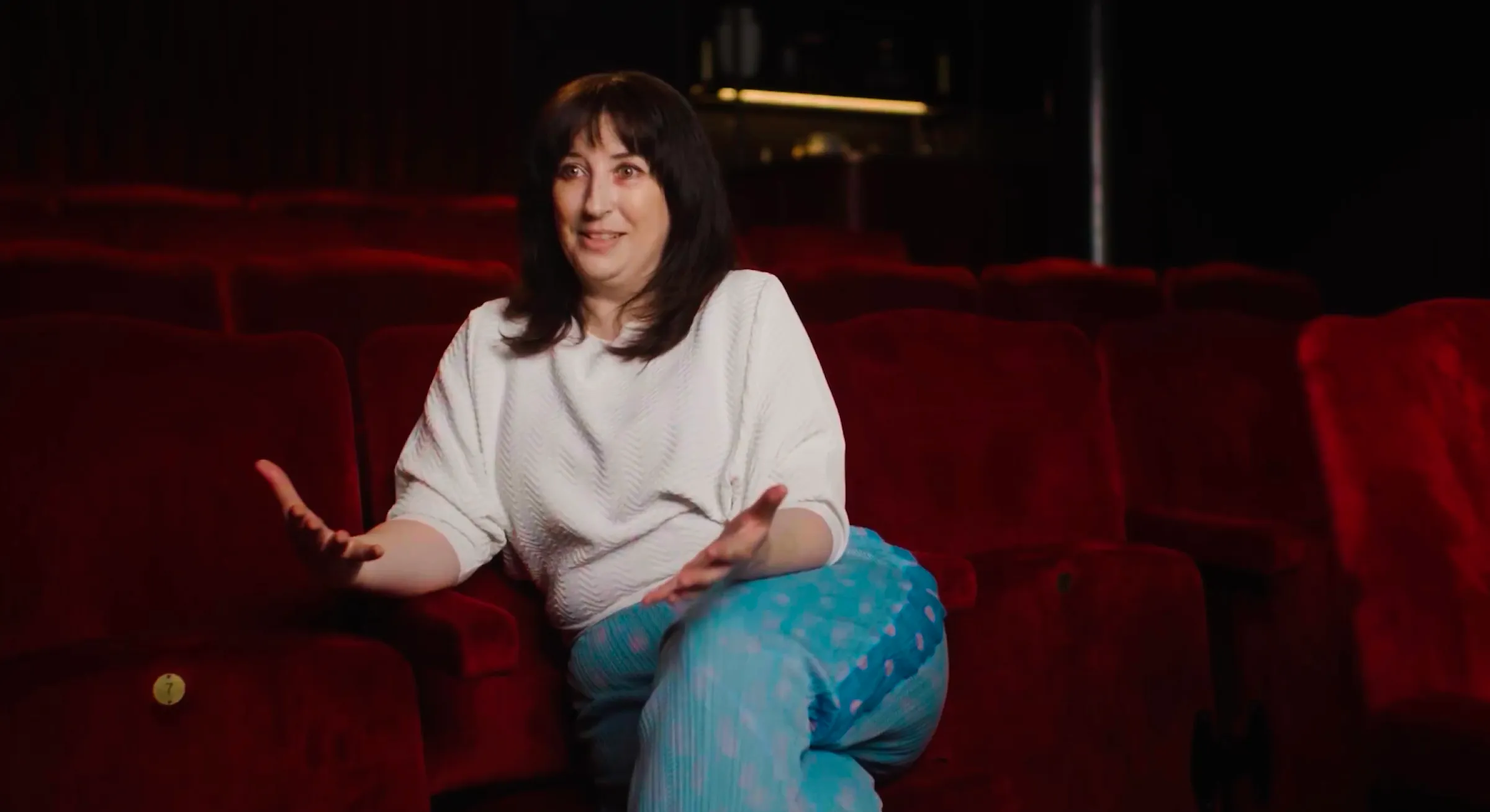 Woman being interviewed in a cinema with red seats for a Dojo Films client testimonial video
