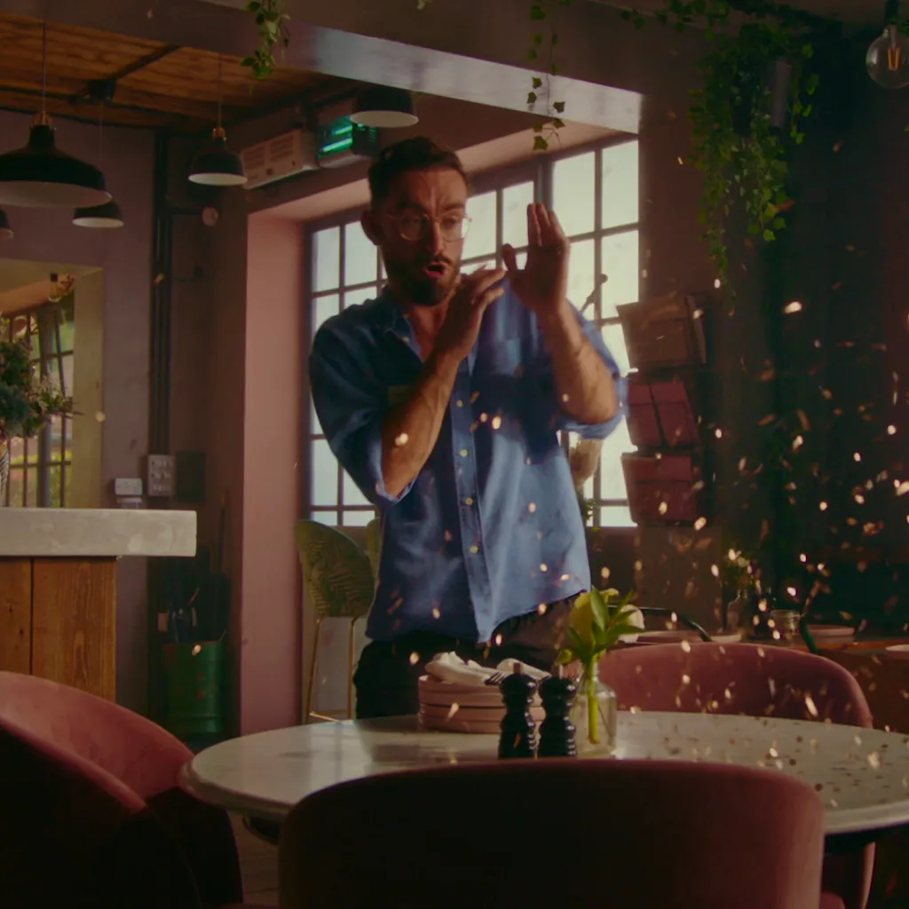 Video still from Dojo Films' SumUp case study showing a man celebrating amid falling confetti in a café setting