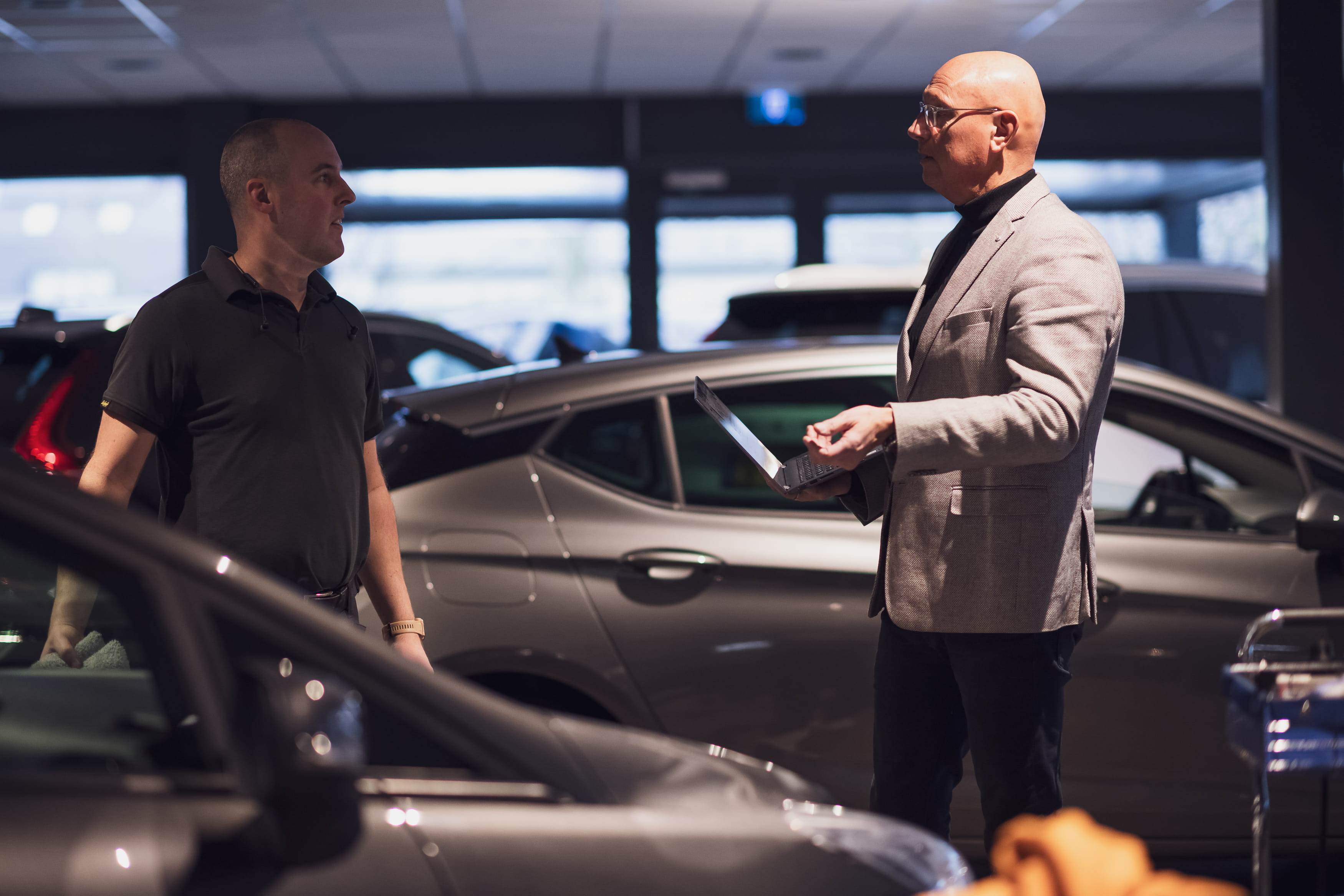 Remco Gemmeke in gesprek met een ondernemer in een autoshowroom