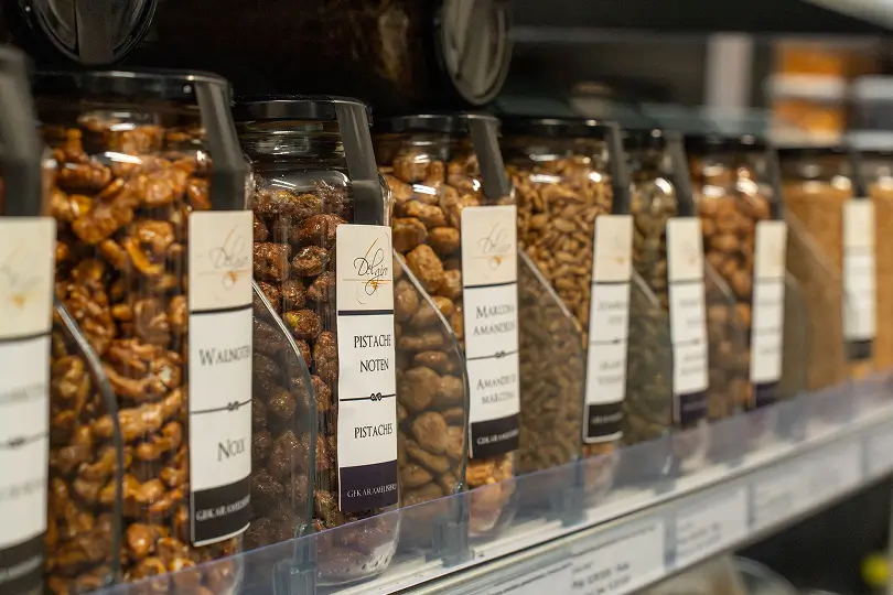 Glazen containers met verschillende soorten noten in een winkelrekken.