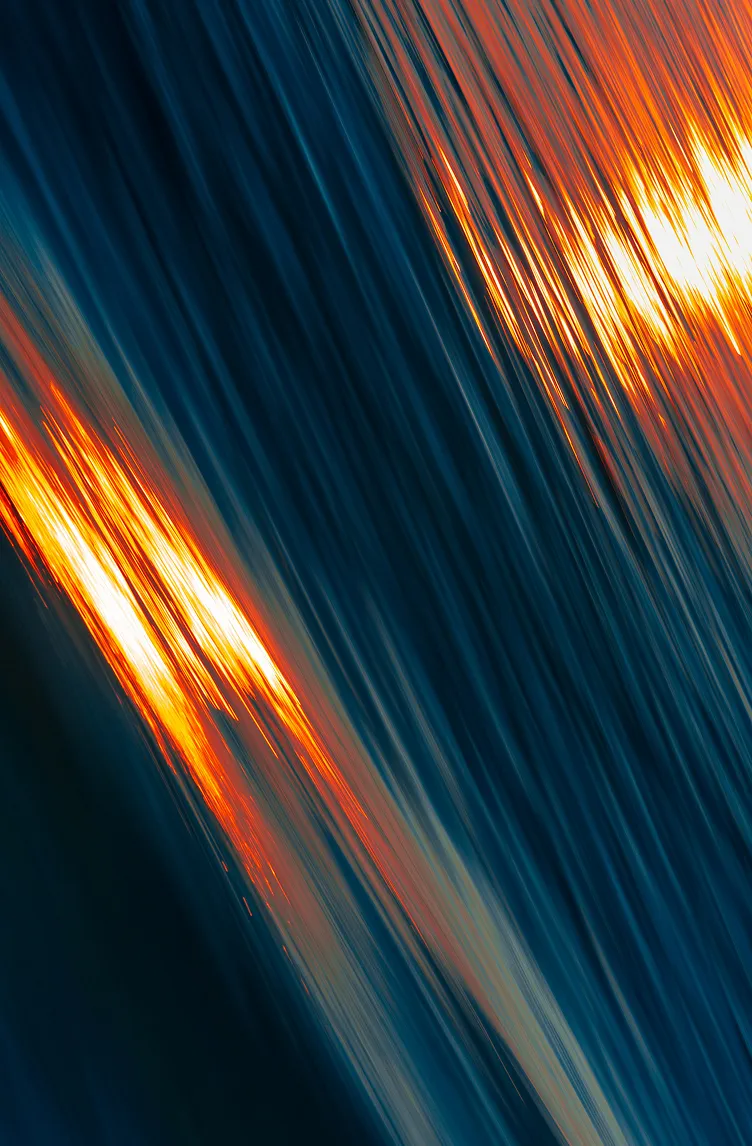 Abstract close-up of flowing water with orange and blue light reflections.