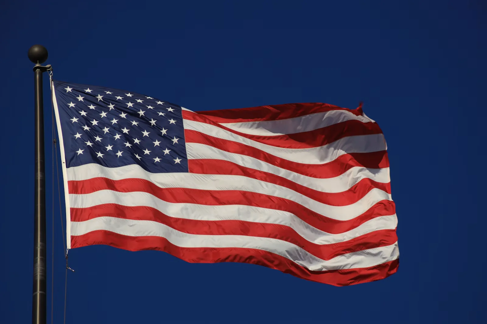 American flag waving against a deep blue sky