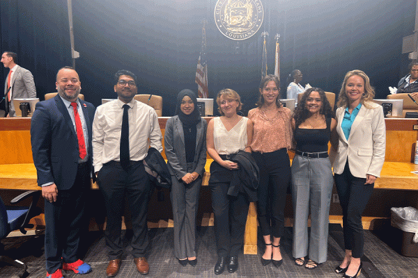 New Orleans City Councilmembers JP Morrell (far left) and Helena Moreno (far right) congratulate the first cohort of Wind Scholars in council chambers.