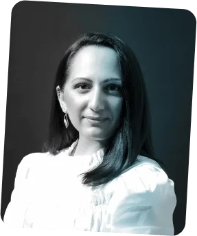 Portrait of a woman with long dark hair wearing a white blouse and dangling earrings.