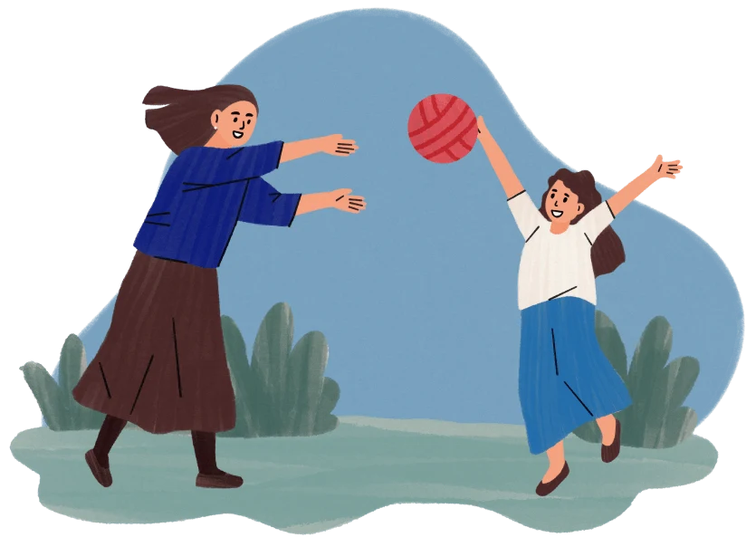 Two women playing with a red ball outdoors with green plants in the background.