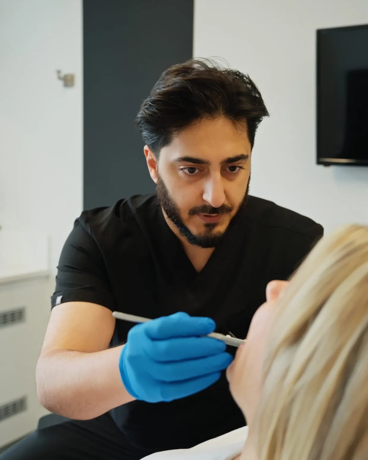 Dr Hamza examining a patient at Sale Dental Spa