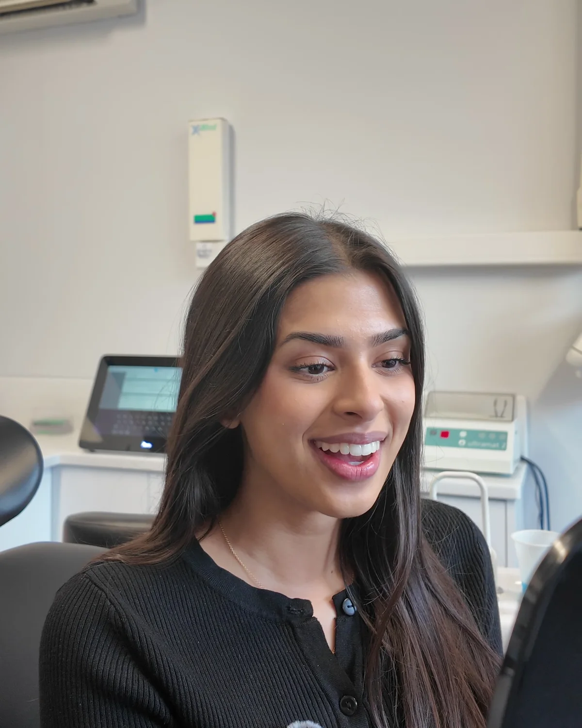A Sale Dental Spa clear aligner patient seeing her new smile in the mirror
