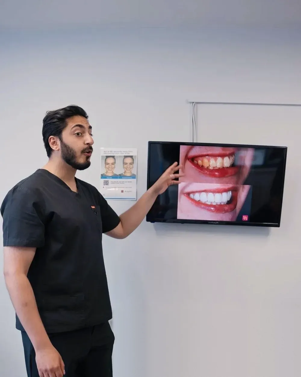 Dr Hamza Mirza pointing to a new smile designed on screen at Sale Dental Spa