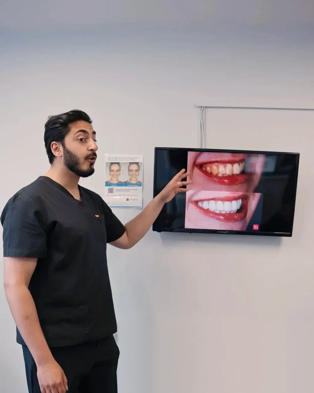 Dr Hamza Mirza pointing to a new smile designed on screen at Sale Dental Spa