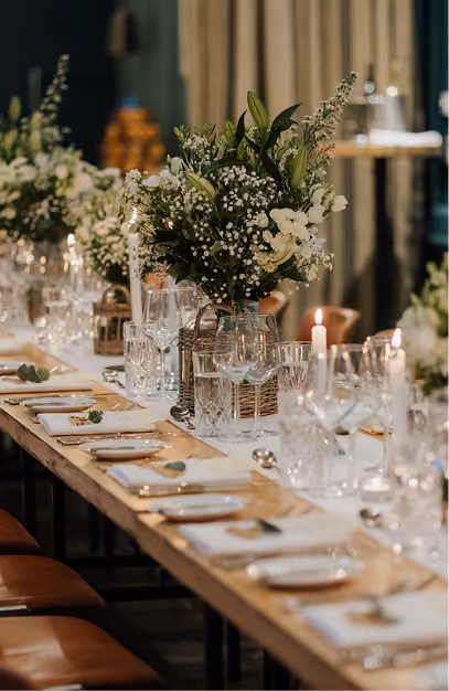 Long wedding table set with white florals, cut crystal glasses and taper candles