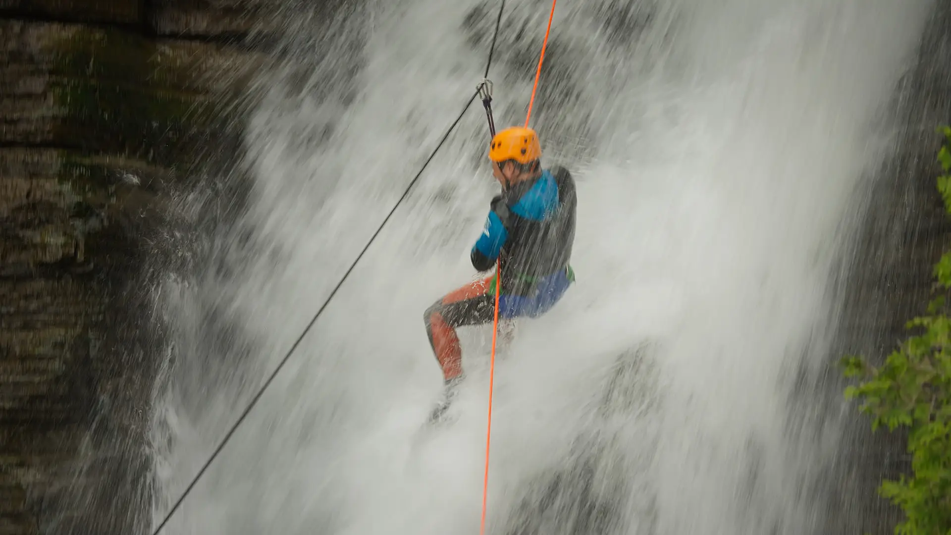 Personne descendant en rappel une chute d'eau, casque orange — vidéo corporative Le meilleur des deux mondes