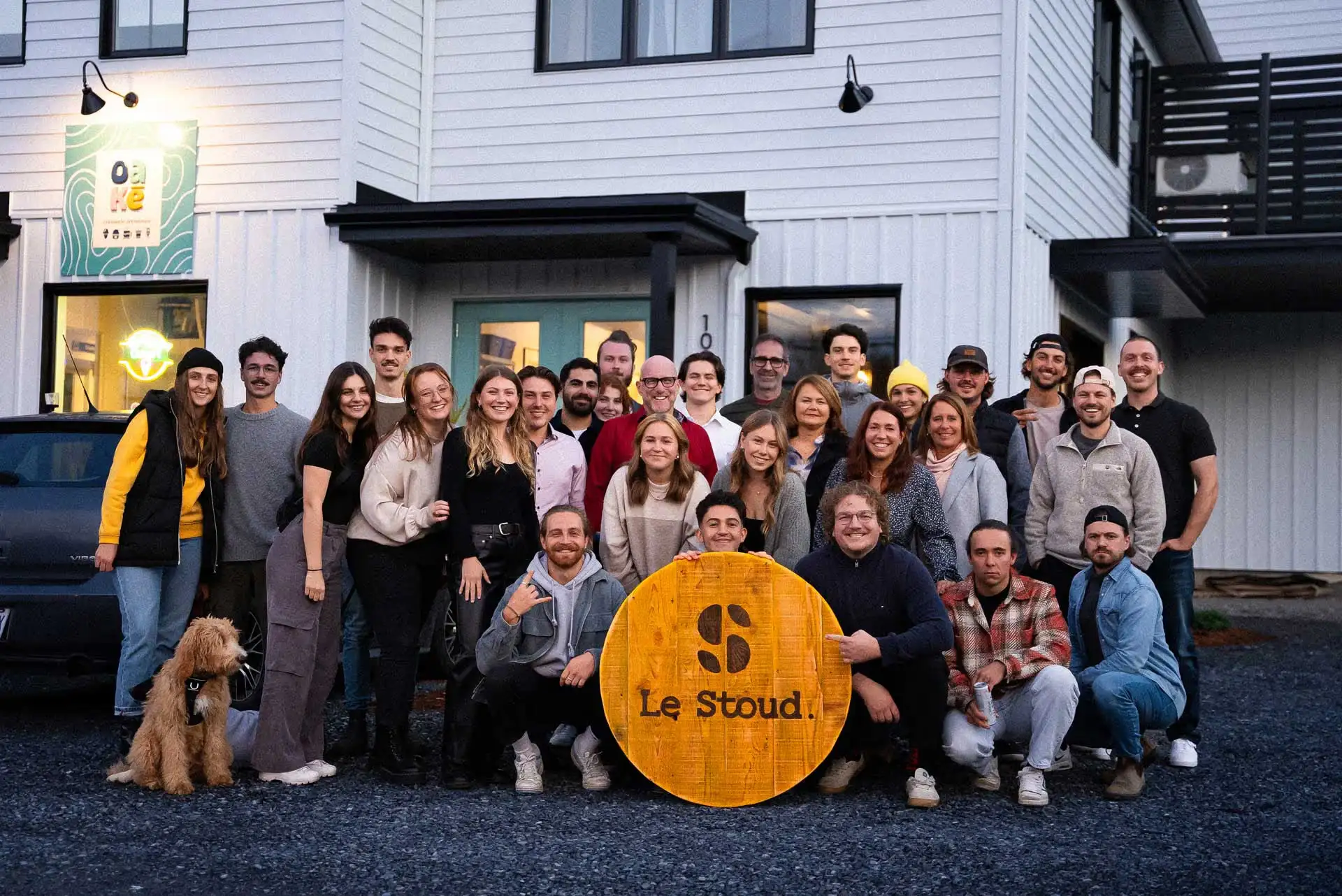 L'équipe du Stoud réunie devant le bâtiment, autour de l'enseigne de bois Le Stoud