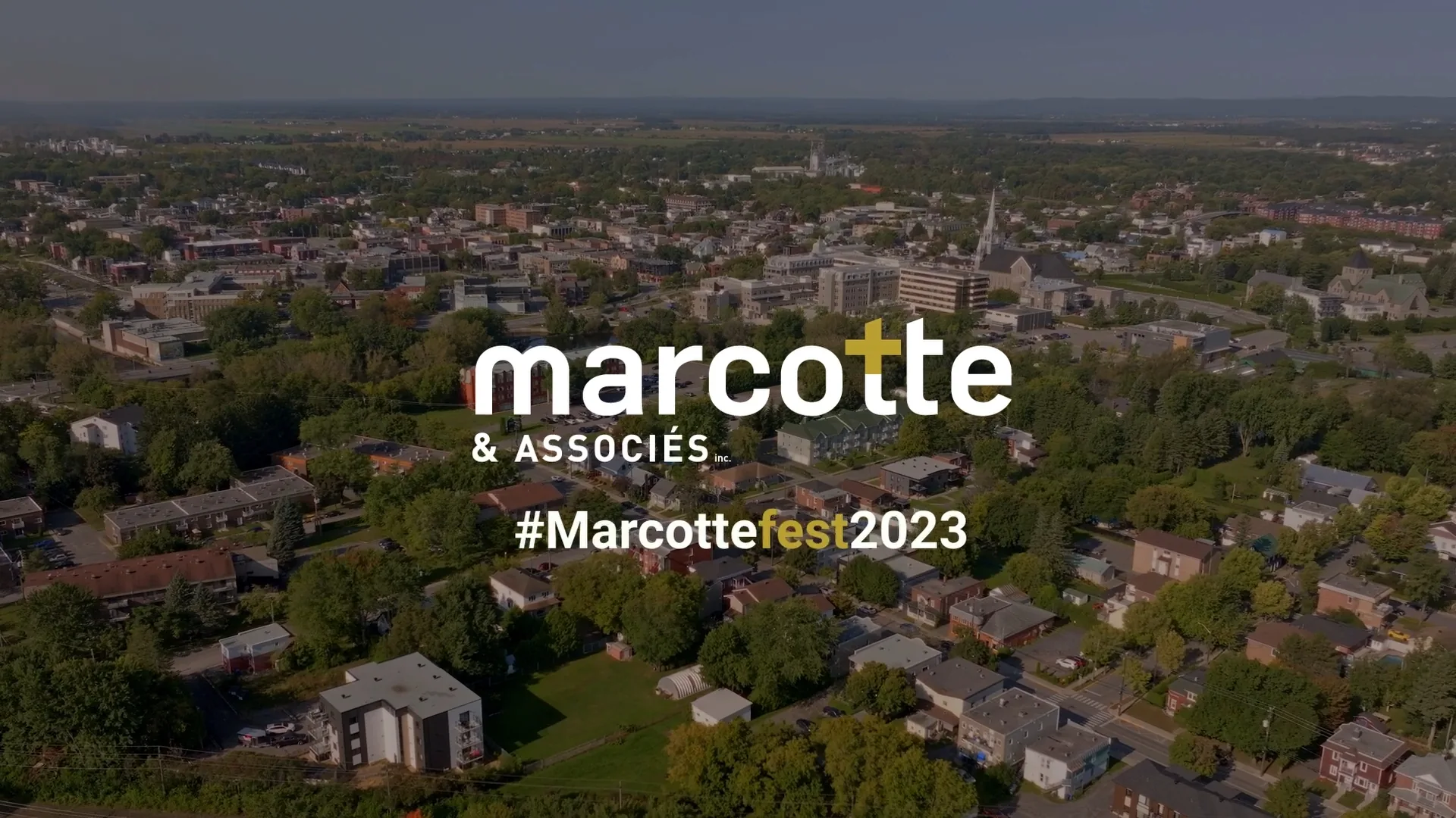 Vue aérienne au drone d'une ville et de ses quartiers résidentiels sous le logo Marcotte & Associés