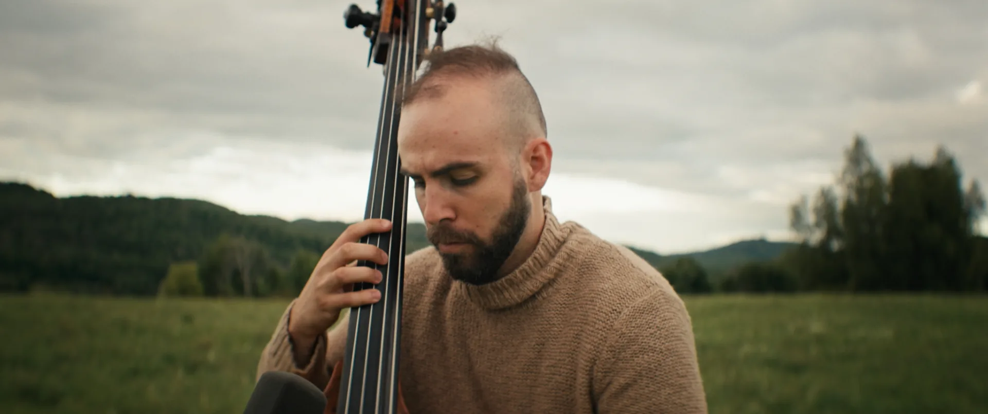 Deux musiciens jouant guitare et contrebasse dans un champ au crépuscule — tournage d'un vidéoclip