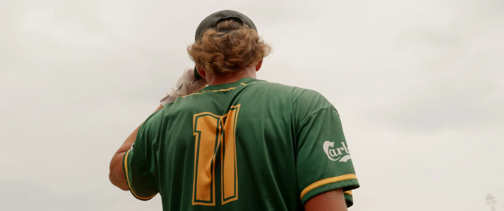 Équipes de balle molle alignées sur le terrain devant les estrades au tournoi Défi Paul Boutin
