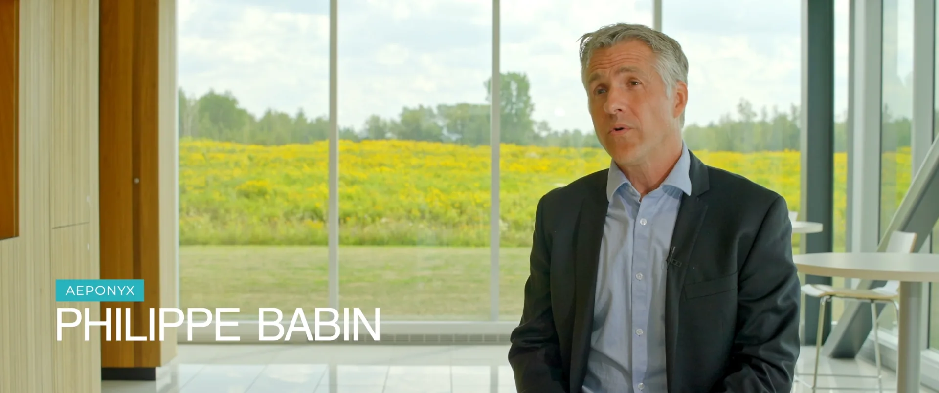 Dirigeant en complet en entrevue dans un couloir vitré et lumineux — vidéo corporative