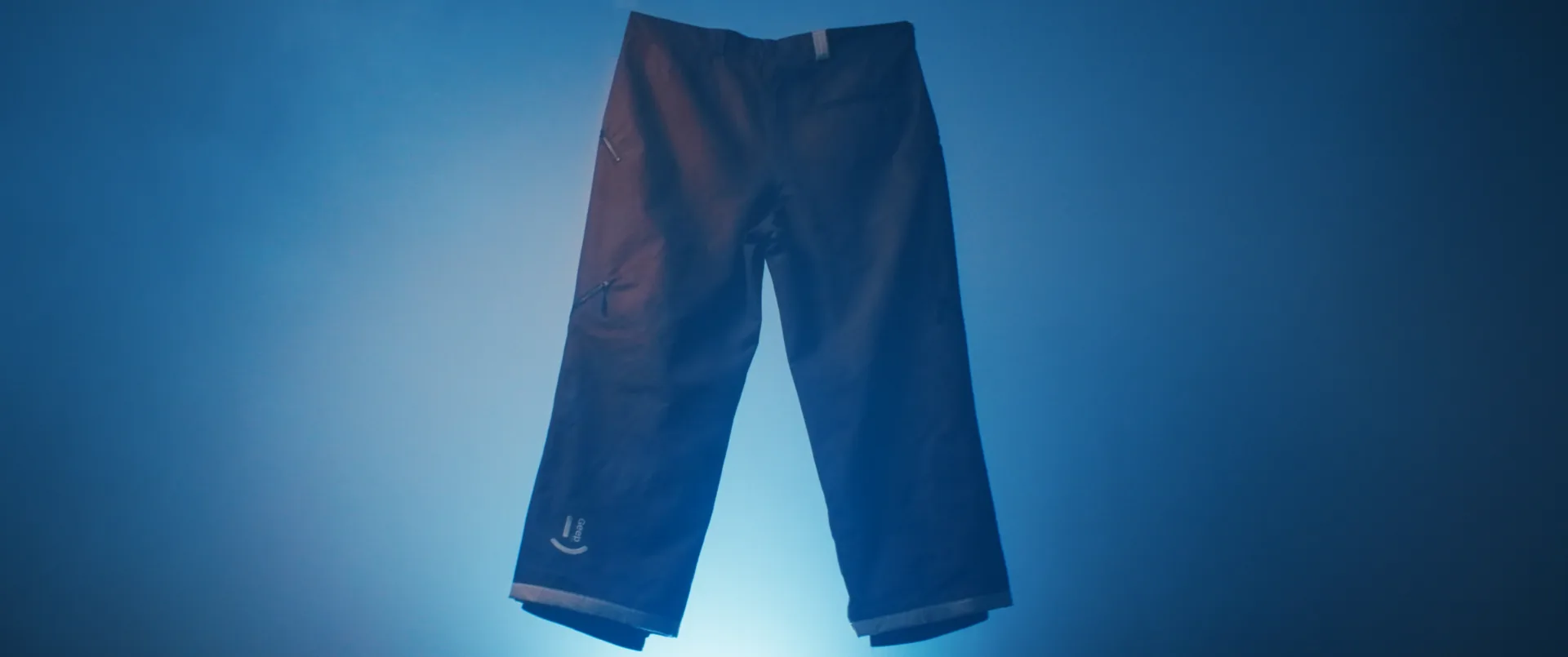 Pantalon de neige suspendu et éclairé sur fond bleu, esthétique studio pour la marque GEEP