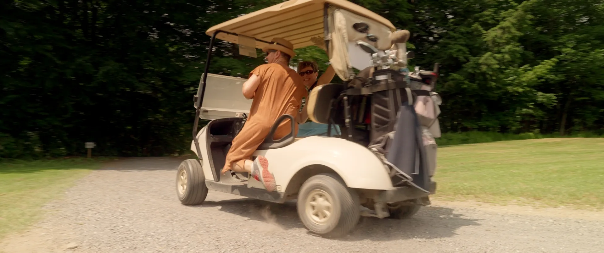 Golfeur en fauteuil roulant motorisé exécutant son élan sur un vert ensoleillé, golf adapté