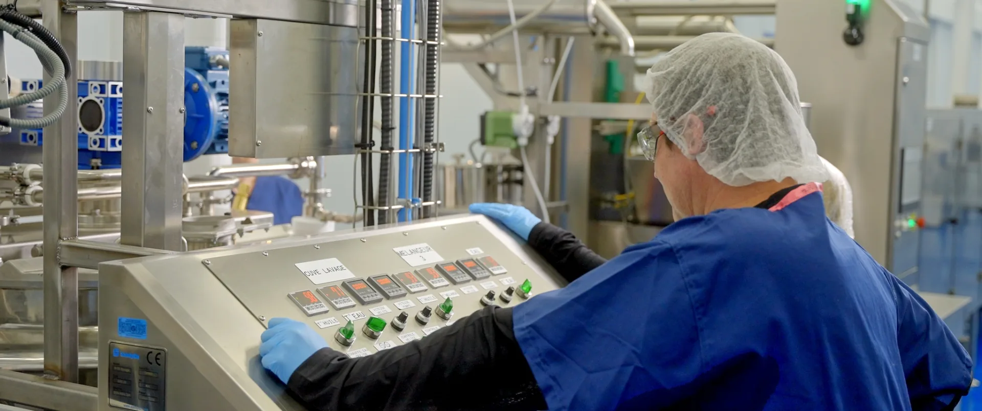 Chaîne de production industrielle en marche, capsules rouges défilant sur un convoyeur en usine