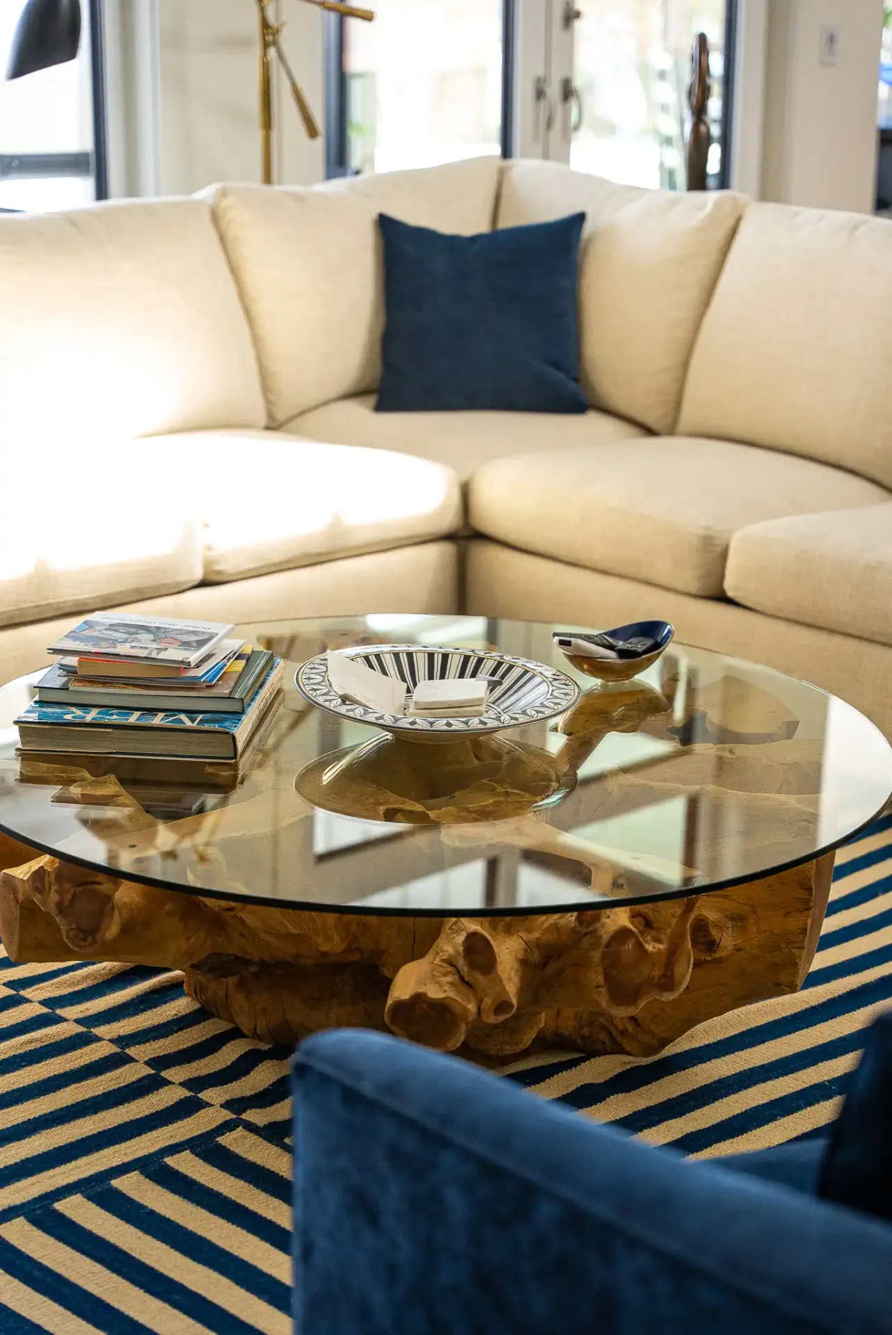 Sectionnel crème et table basse ronde sur un tapis rayé