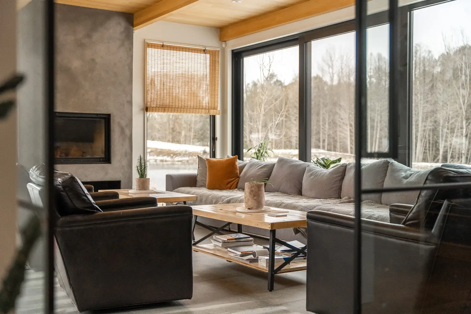 Salon au foyer encastré ouvert sur la forêt enneigée