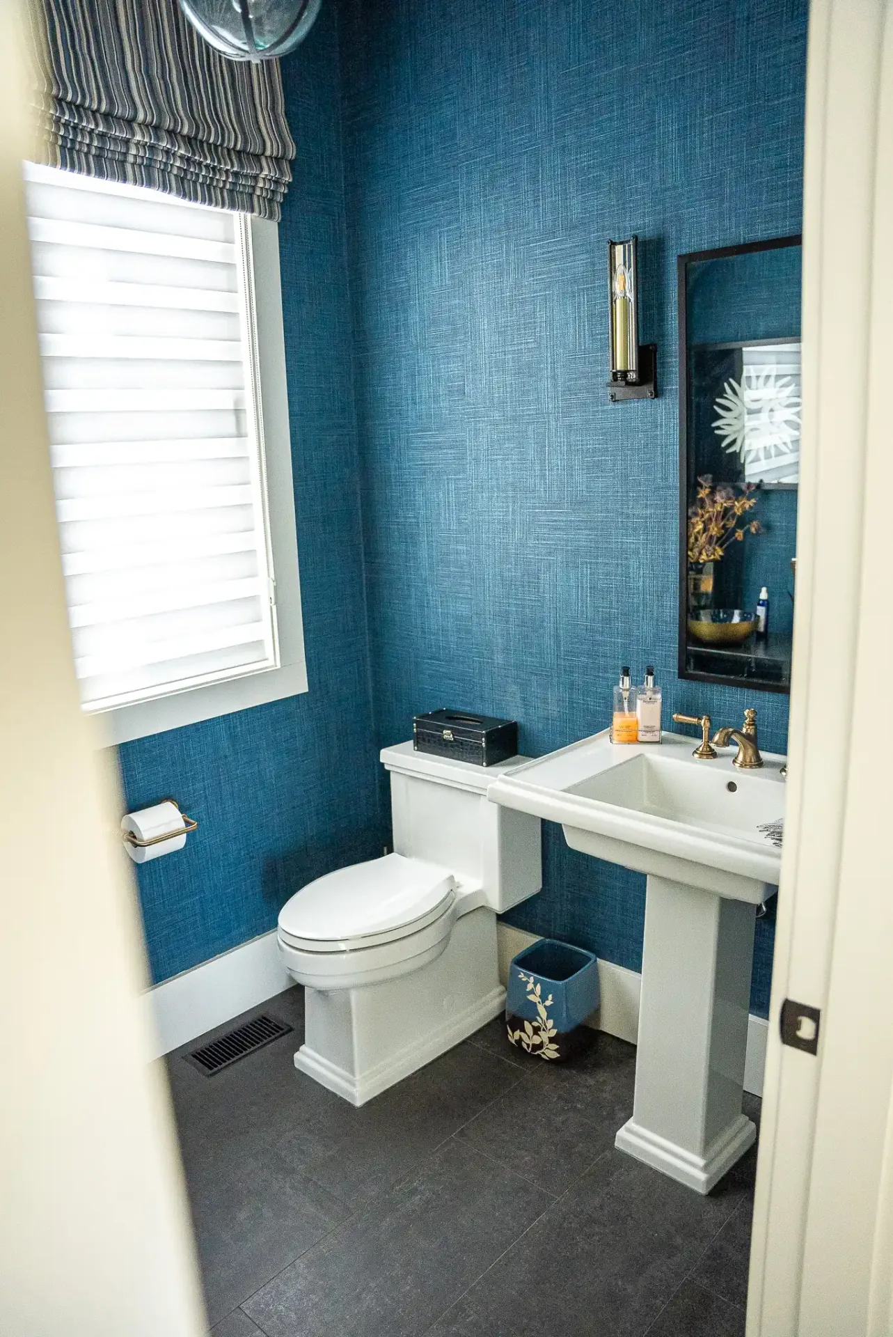 Salle d'eau habillée de bleu profond, lavabo sur colonne