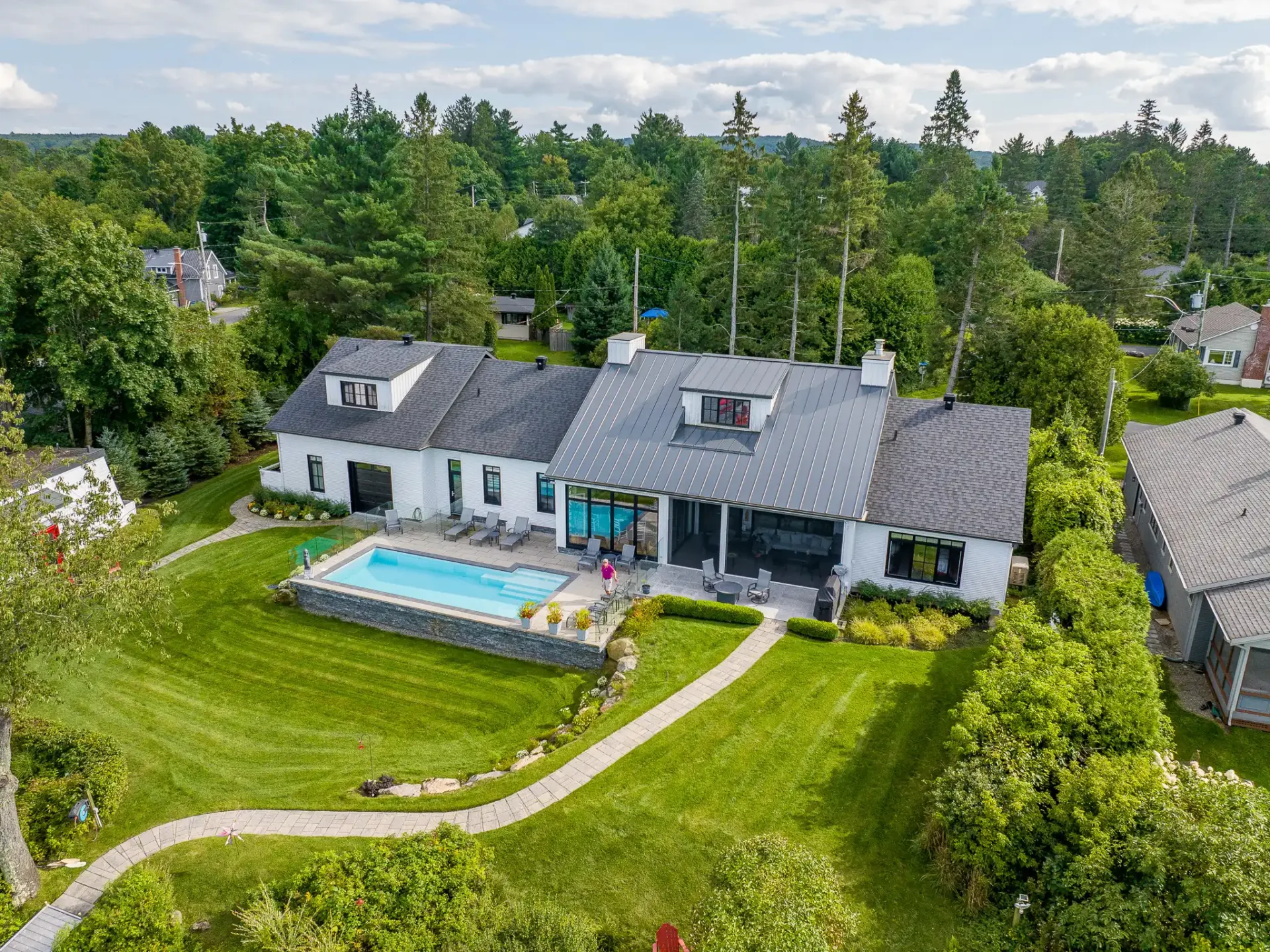 Vue aérienne d'une résidence blanche et de sa piscine creusée
