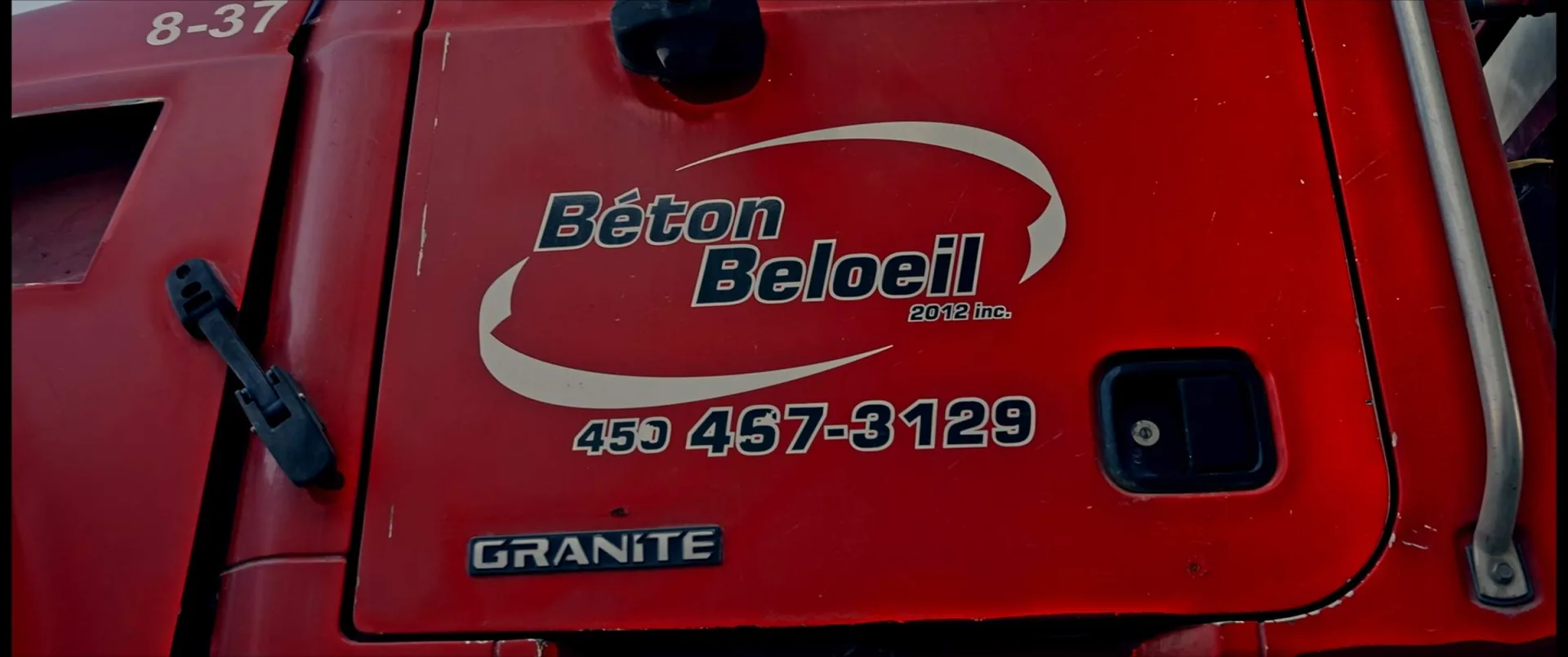 Usine de béton et ses camions malaxeurs vus des airs, au milieu des champs