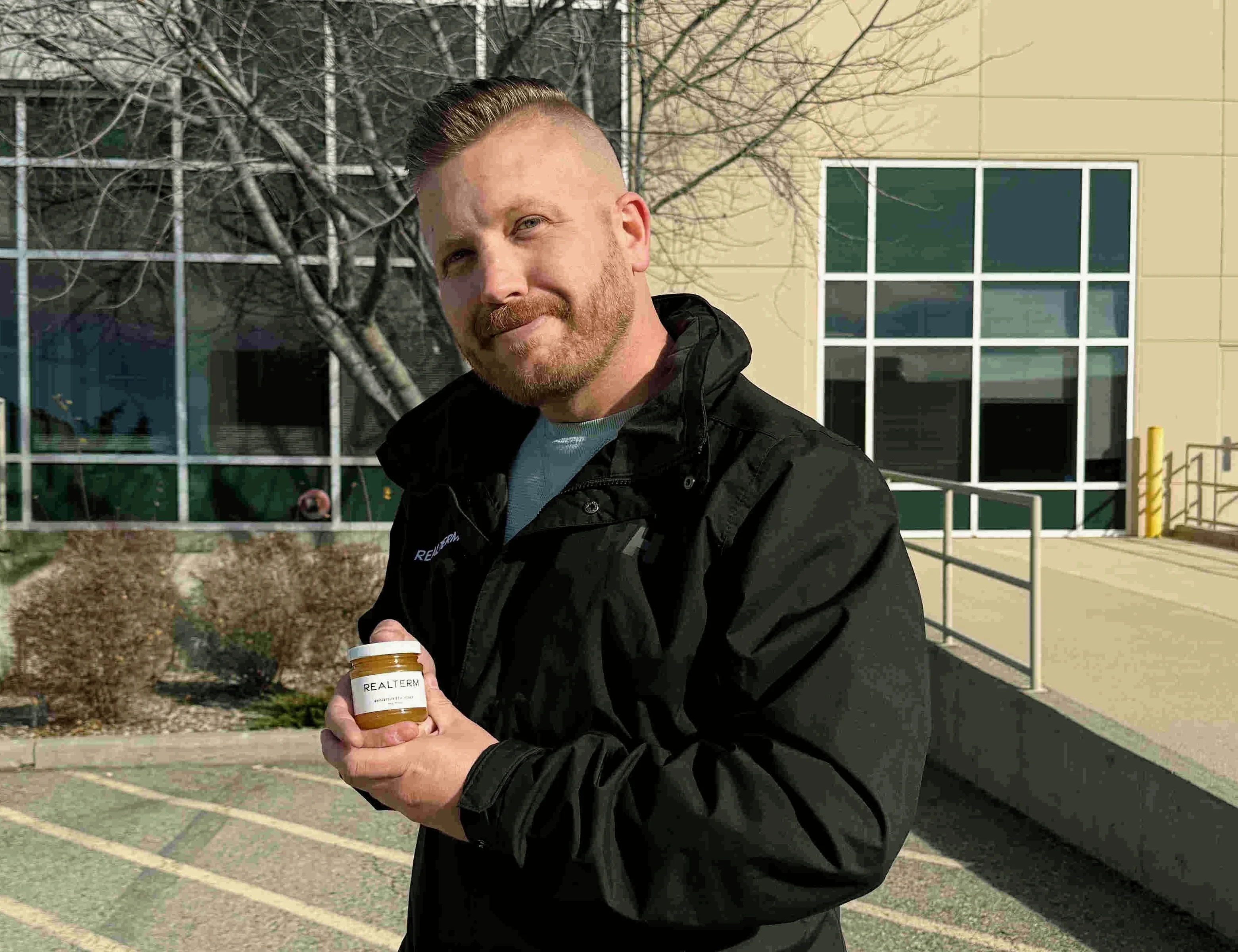 Realterm employee holding an Alvéole honey jar