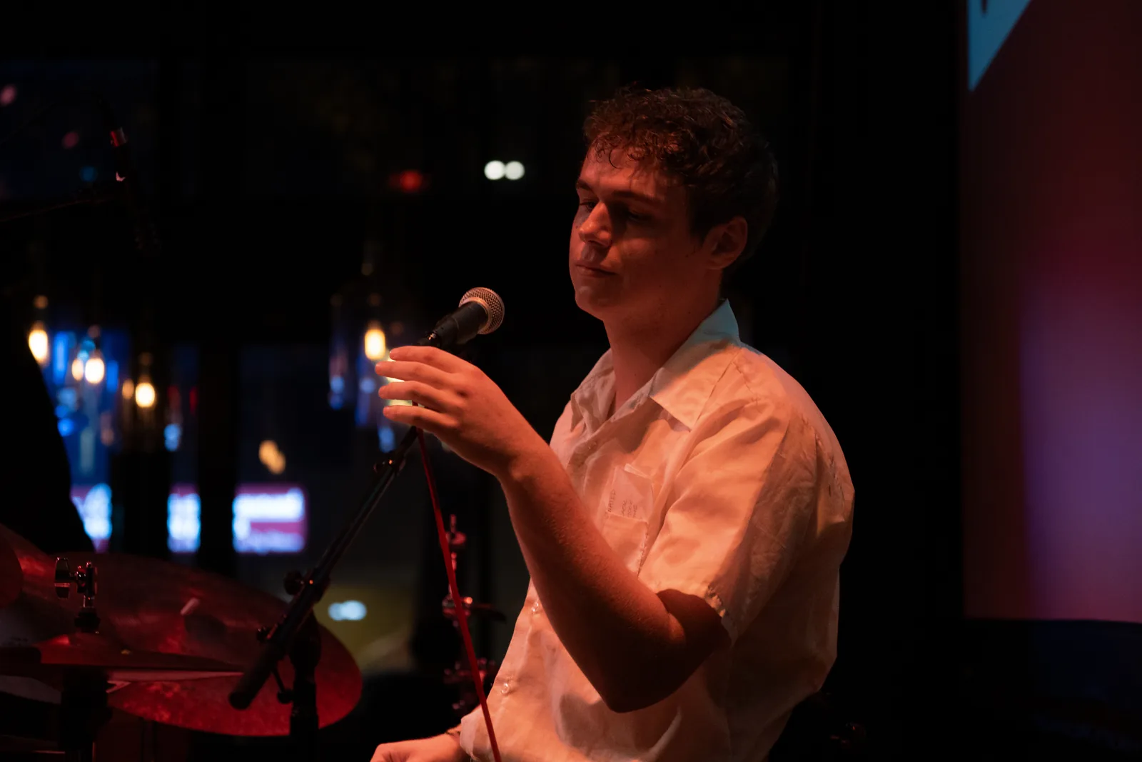 A performer at the microphone during a Campfire Music Foundation show.