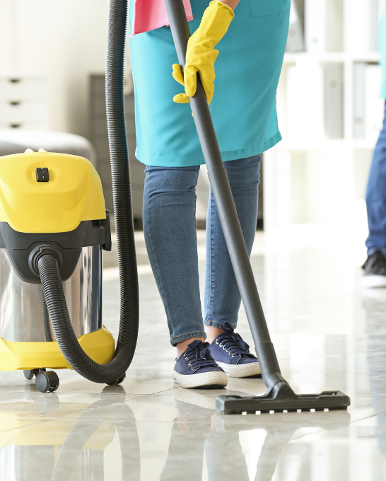 Professional cleaner vacuuming an office floor next to a commercial vacuum cleaner, alongside text describing GenMar's commercial cleaning services in Ottawa.