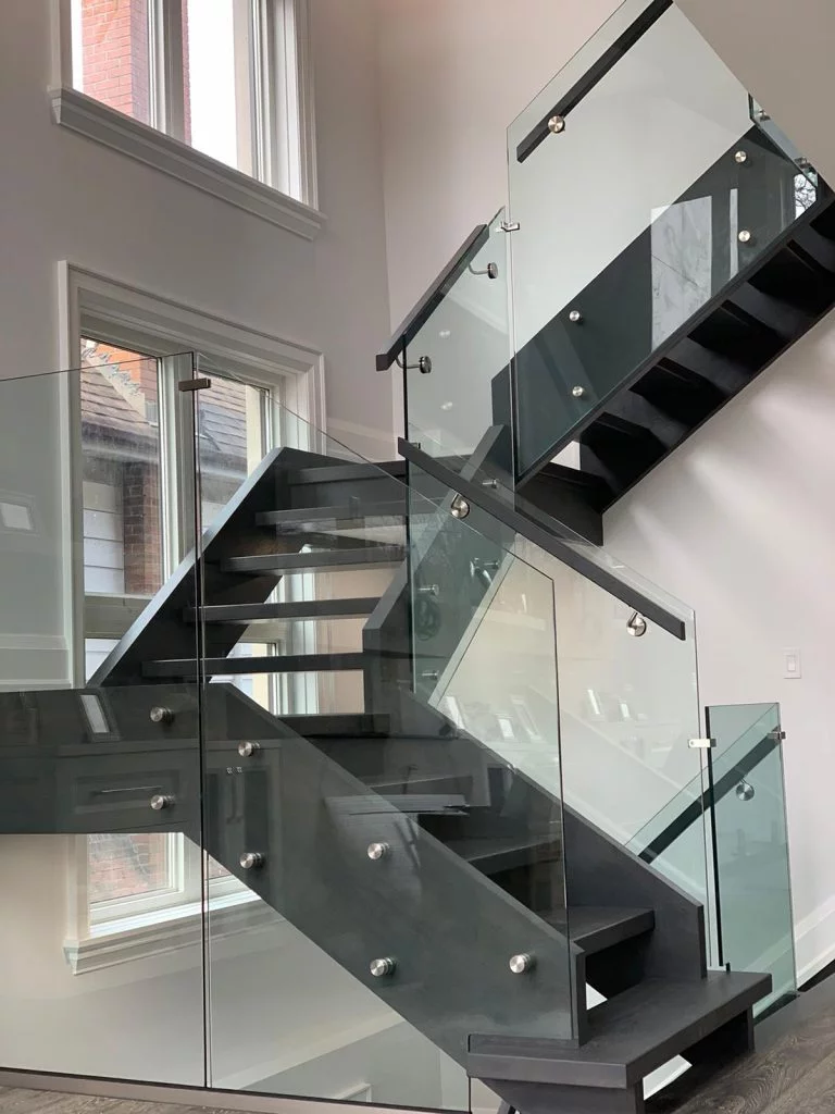 Interior glass railing installation for a modern staircase in Winnipeg home.