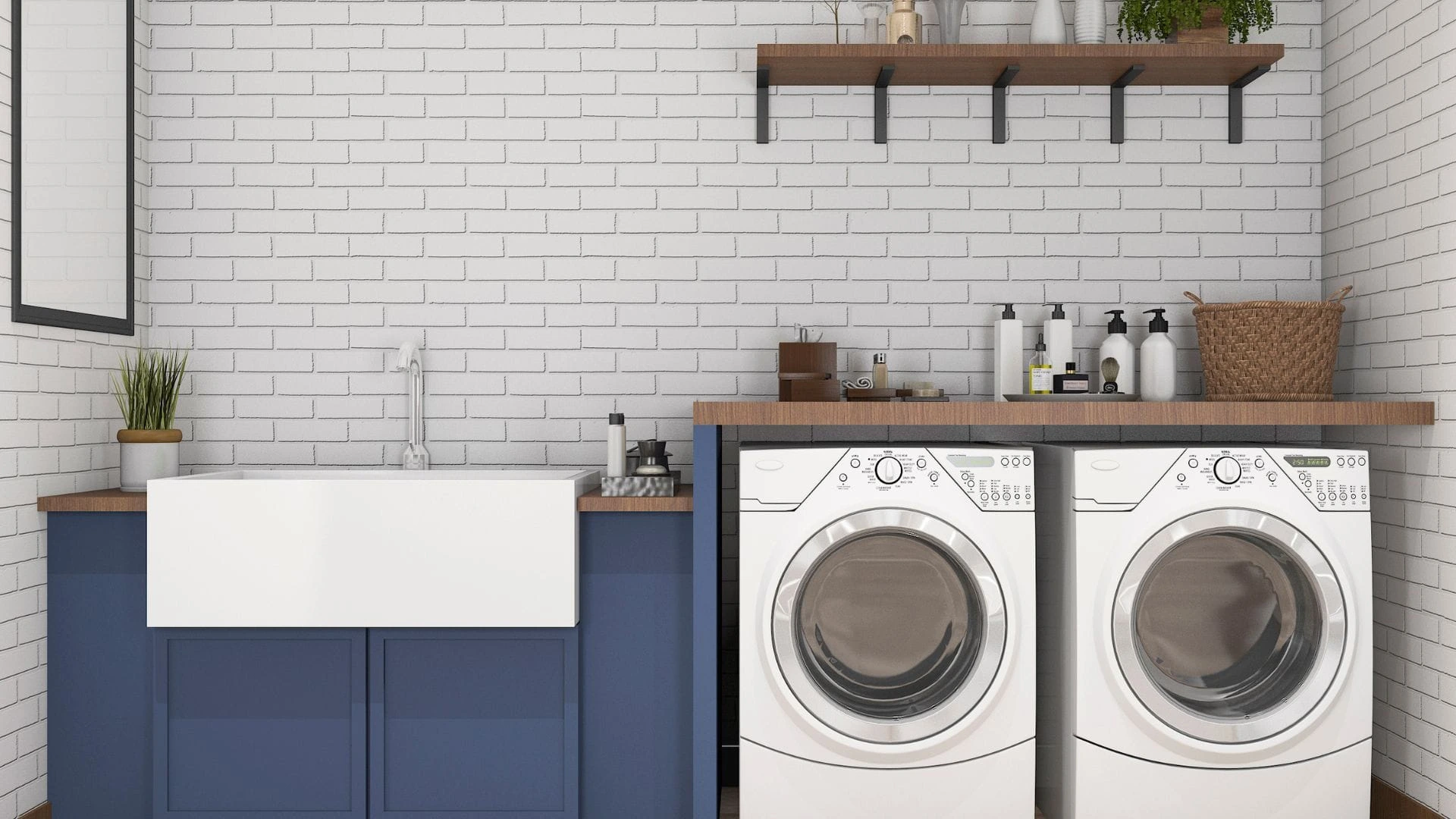 Laundry room with navy cabinets, farmhouse sink, white front-load washer and dryer, and wooden shelf with decor.