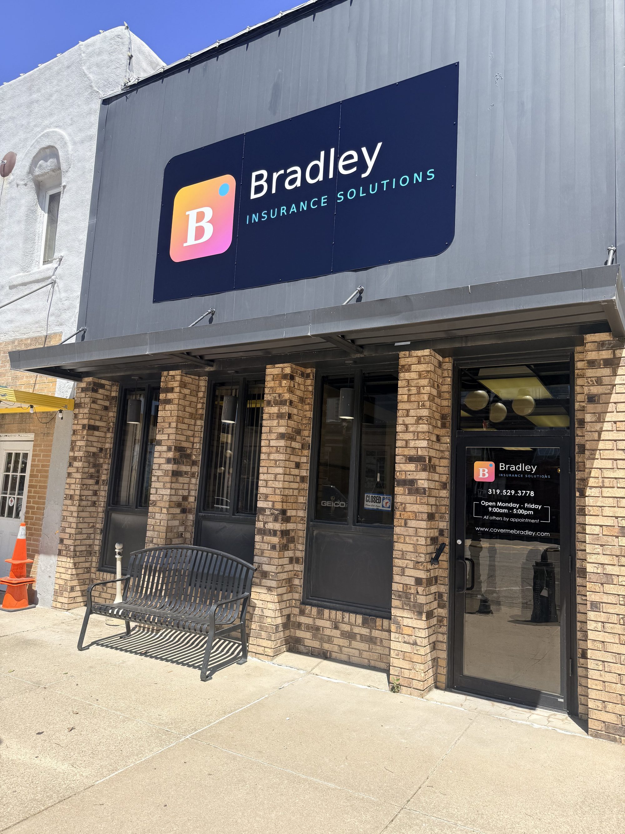 Bradley Insurance Solutions storefront in Traer, Iowa &mdash; the B mark sign over the brick office entrance
