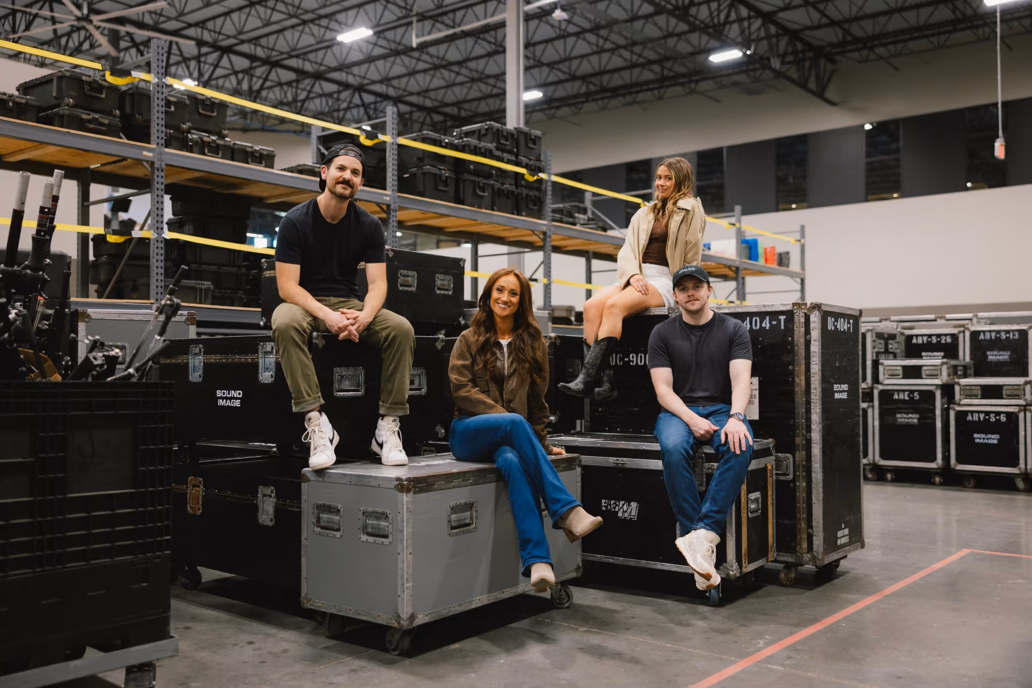 Giggs team sitting on large stage boxes in a music performance space.