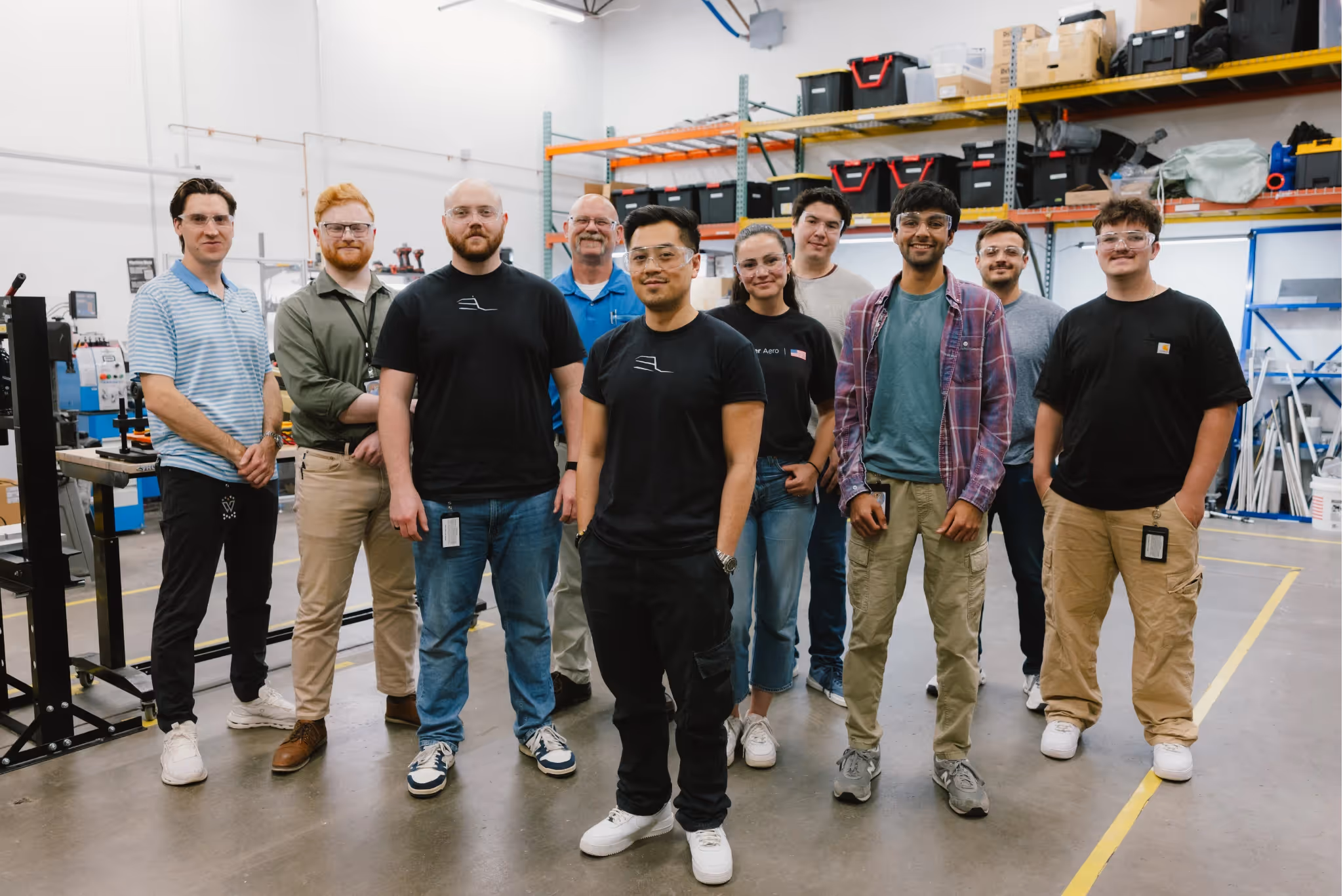 Group shot of Whisper Aero team members standing together in their production & engineering facility.