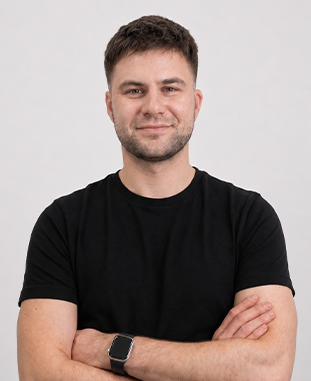 Uśmiechnięta kobieta w ciemnoniebieskim swetrze na białym tle.