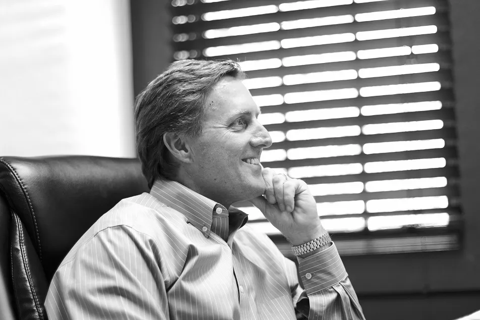 Black and white photo of a smiling woman sitting in an office chair