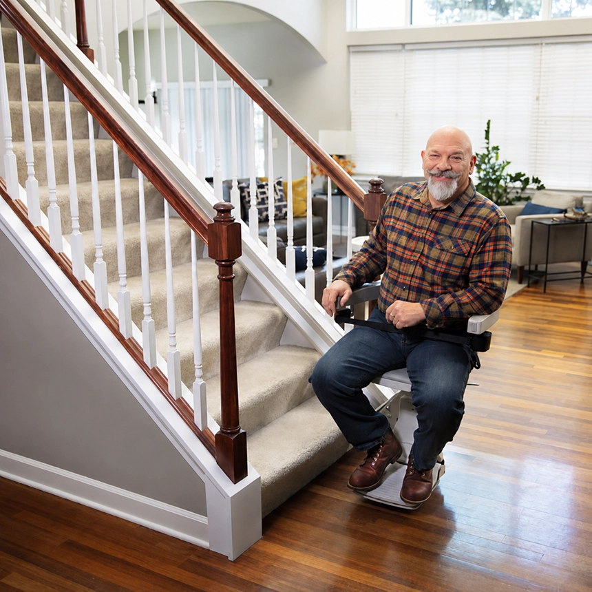 Older man using Bruno Elan straight stairlift installed by Simple Comforts