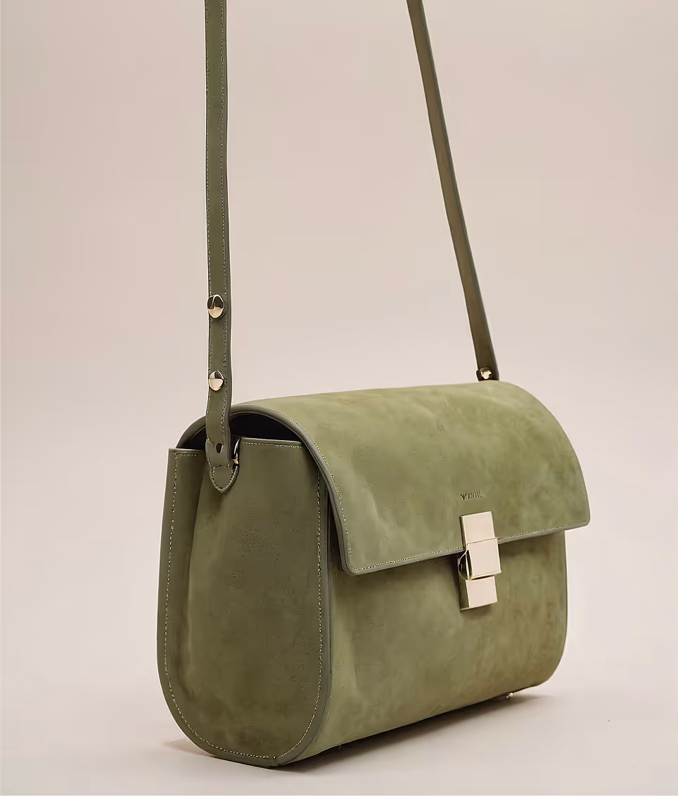 Olive green suede shoulder bag with gold clasp and adjustable strap on a plain background.