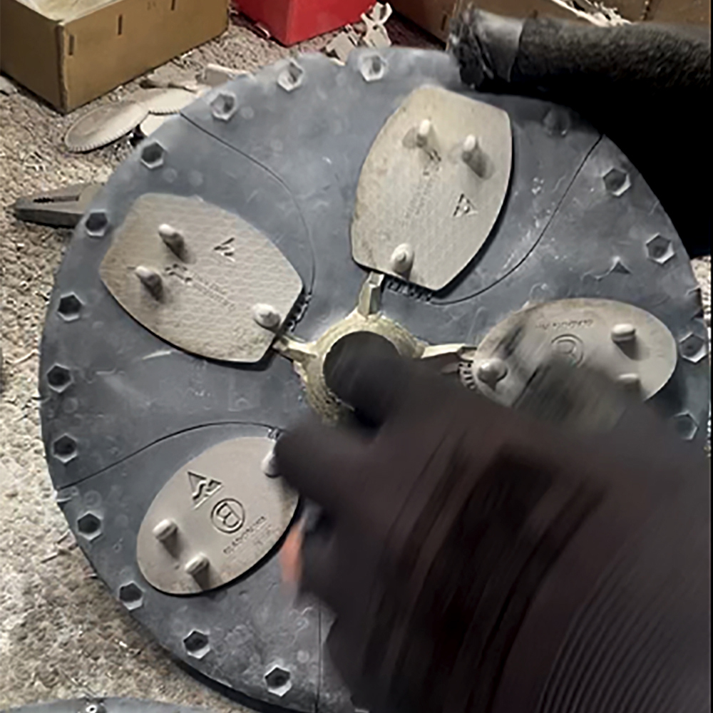 Custom pewter buckles being removed from a production casting mould during manufacturing process